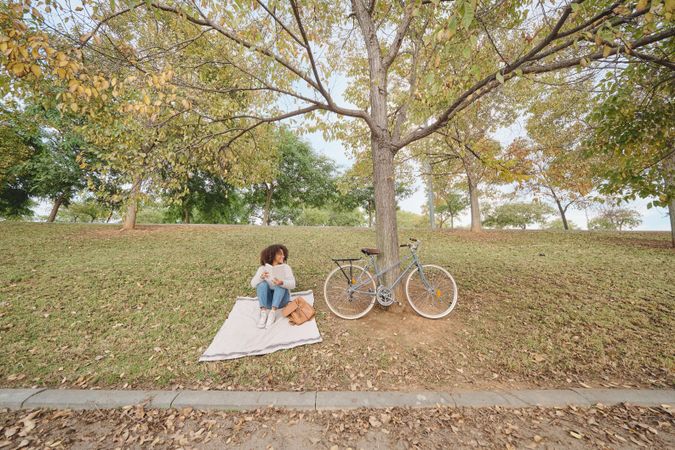 Young Black woman reading book in park
