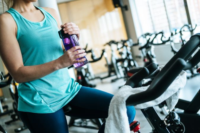 Woman drinking water on exercise machine