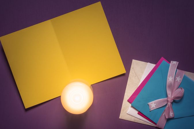 Top view of blank yellow message card and candle