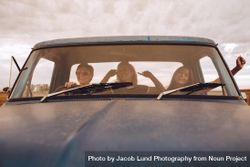 Three young women enjoying in car during vacation 0LyJg5