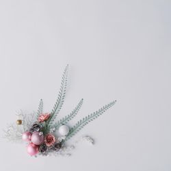 Winter composition with flowers, leaves and pink Christmas decoration