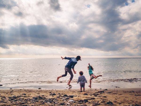 dad playing with kids at beach