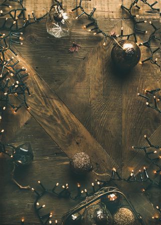 Christmas tree decorations, arranged on wooden counter, with copy space in center