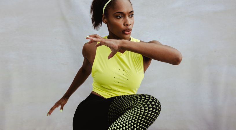 Black woman in fitness wear exercising outdoors