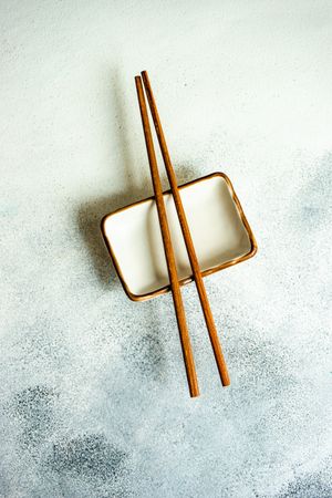 Top view of chopsticks on dipping sauce dish