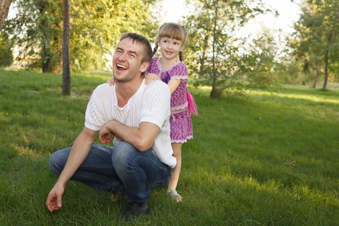 Man and girl laugh and smile in city park
