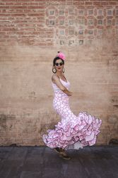 Passionate woman in flamenco dress dancing on street