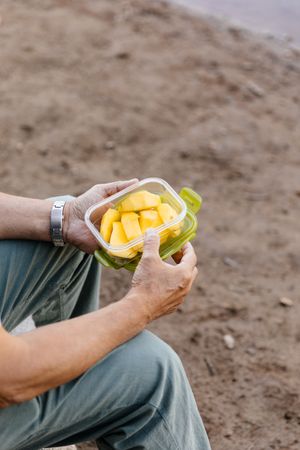 Man hands eating mango