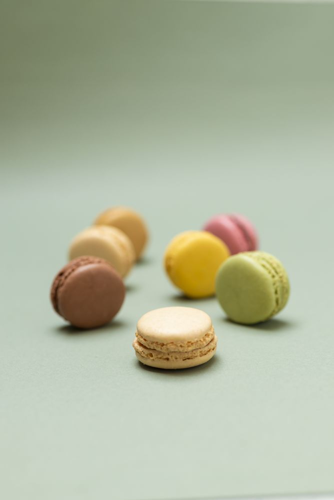 Pastel macaroon desserts on a marble background, vertical