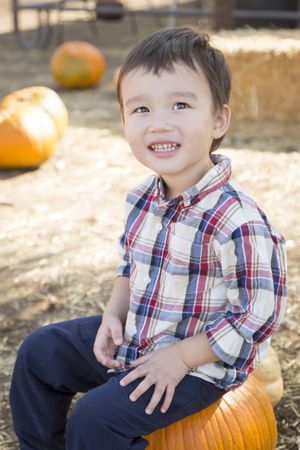Smiling Biracial Young Boy Having Fun at the Pumpkin Patch