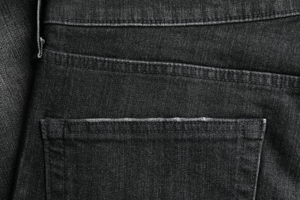Closeup view of jeans pocket as background, space for text