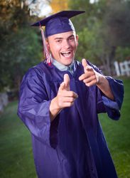 Happy Graduate in Cap and Gown Outside.