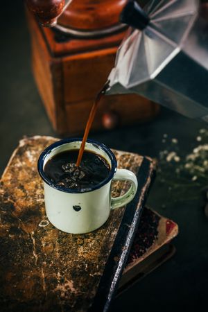Poring hot coffee in an enamel cup
