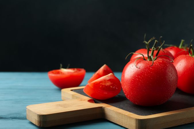 Fresh tomatoes on board on wooden table. Ripe vegetable