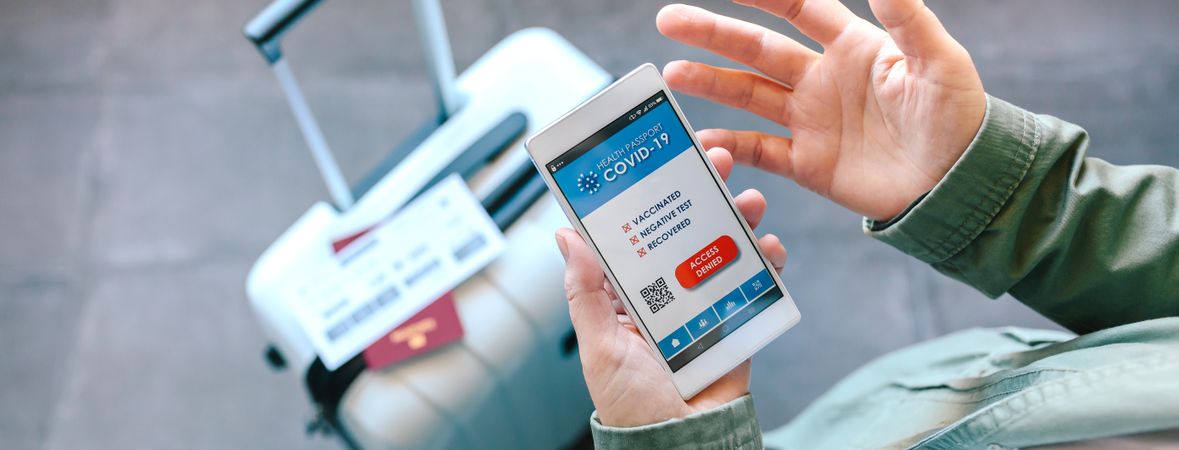 Hands holding a mobile with denied covid passport