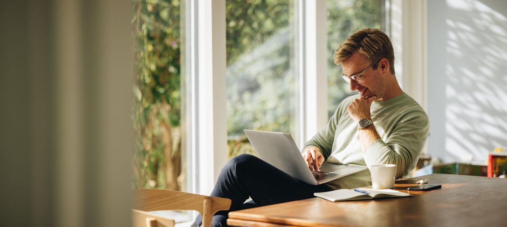 Working man in good mood as he works remotely from home