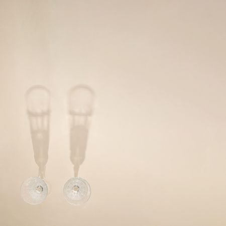 Top view of two champagne glasses on beige table with copy space