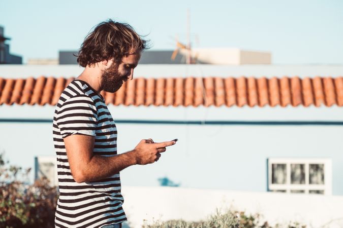 Young male walking with mobile phone