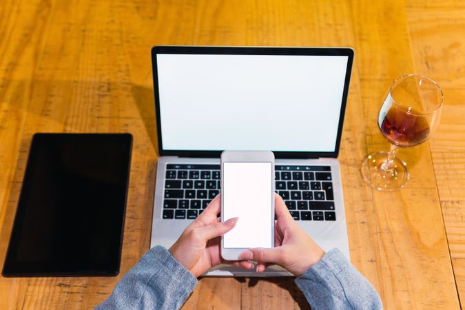 Crop woman using devices in restaurant