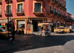 Man walking with food cart across street