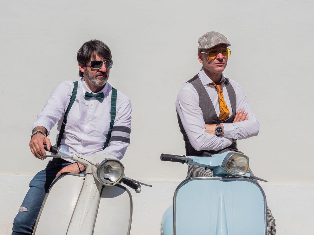 Trendy  men sitting on vintage scooters