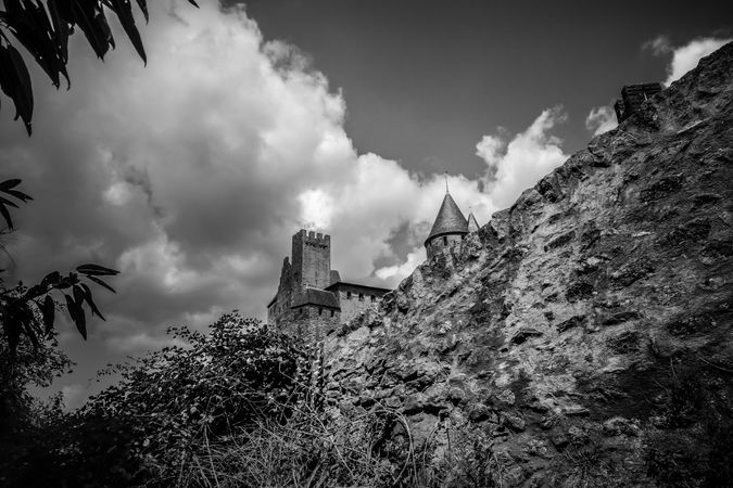 Monochrome shot looking up at old castle from the wall in France