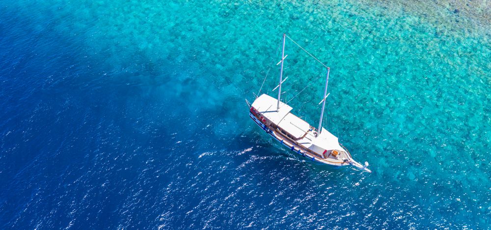 Aerial shot of boat in tropical waters, wide