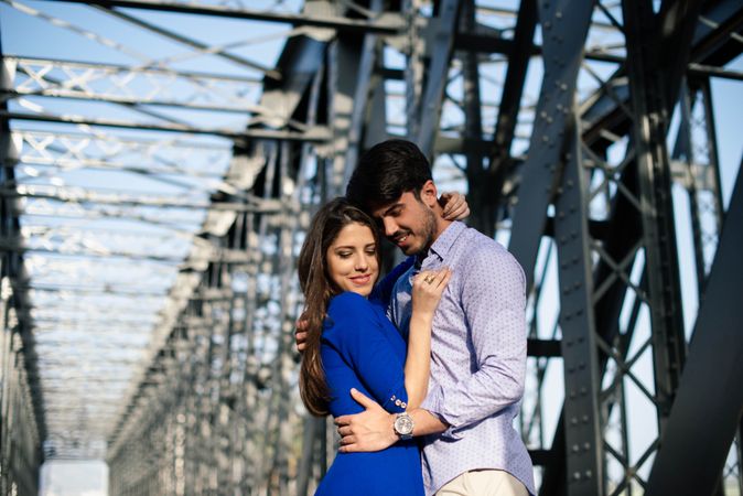Amorous couple bonding on railway under bridge