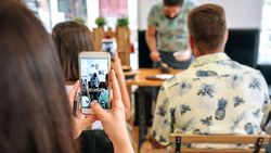 Woman taking photo with mobile in a cooking workshop