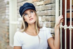 Contenplative woman holding onto window railing
