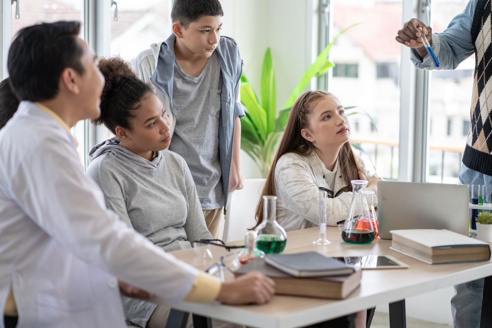 Students focused on teacher holding test tube