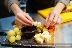 Person plating a cheese board 5neOQ0