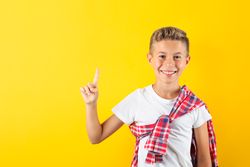 Happy boy against yellow background, space for text