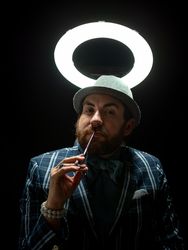 Well dressed man holding scissors and looking at camera