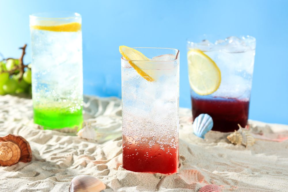 Three Glass of Various Lemonade Summer Drink on Beach Sand Setting