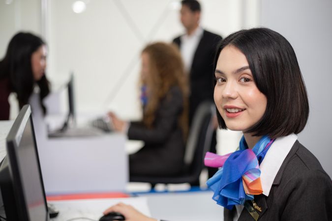 Smiling woman in silk scarf flight attendant uniform working in airport
