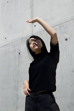 Woman in dark top blocking sunlight with her hand