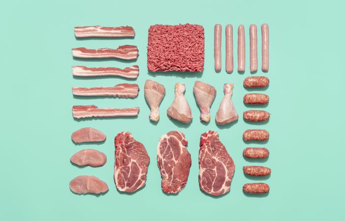 Raw meat variety isolated on a green background, top view