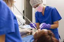 Female dental patient lying back with open mouth during exam