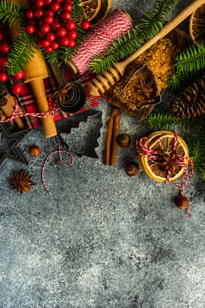 Christmas baking ingredients and tree shaped cookie cutters on concrete counter with copy space