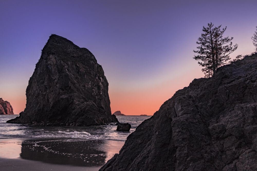 Rocks on the coast at sunset with beautiful purple orange sky