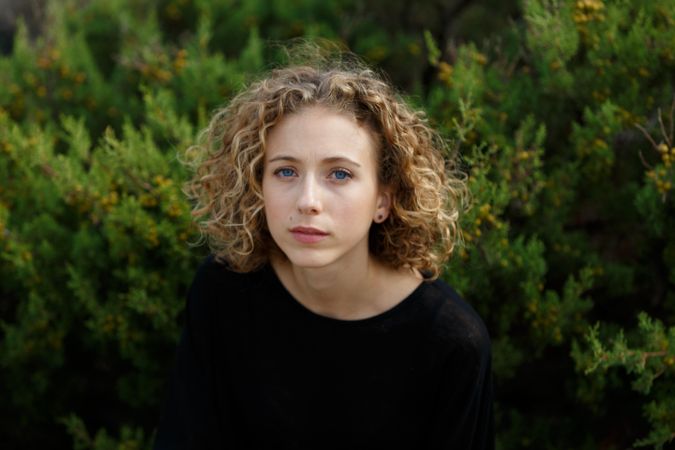 Young woman near dry twigs of bushes