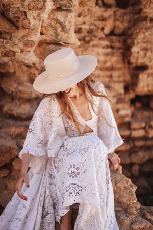 female sitting by ruined wall