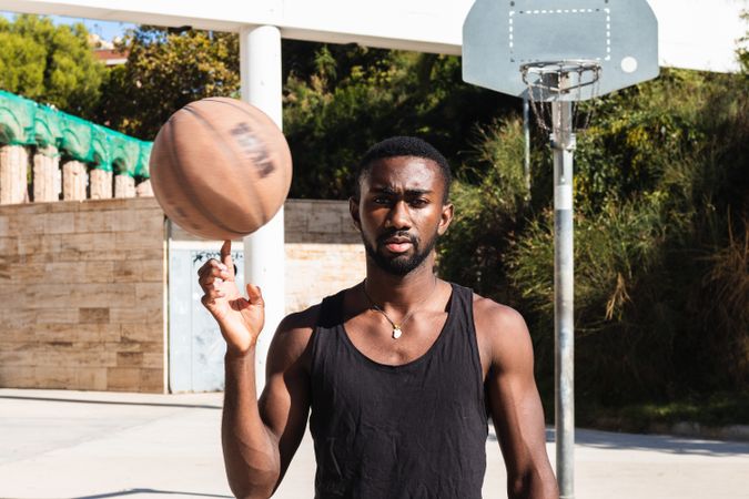 Black man spinning basketball on finger