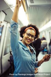 Woman holding cell phone and smiling on public transport 5o63g0