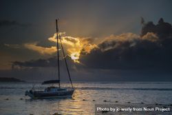 Sailboat anchored in Indian Ocean with the sunsetting in the background 0K2oAb
