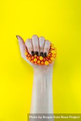 Person holding orange and yellow beads 48nxq0