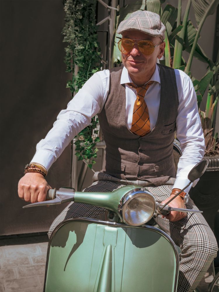 Trendy man sitting on vintage scooter