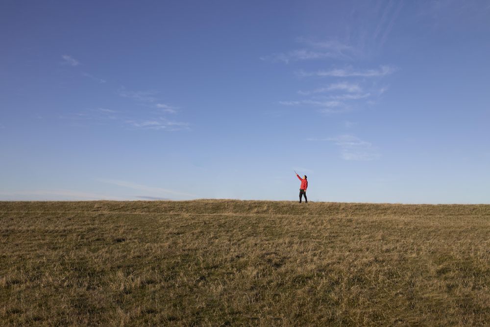 Man pointing at sky from field
