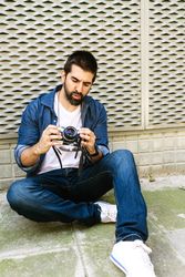 Man in denim setting up camera